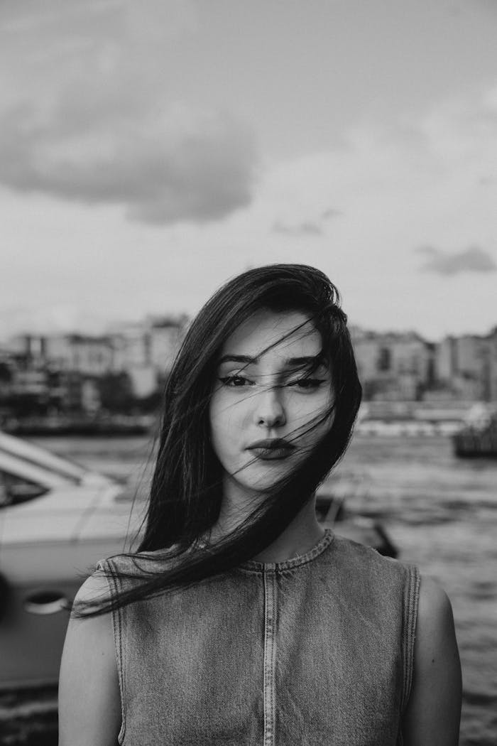 Black and white portrait of a woman with cityscape background along Istanbul's shore.